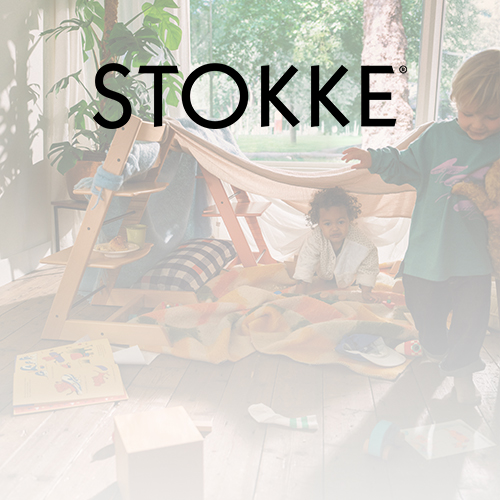 Zwei Kinder spielen drinnen mit einem hölzernen Spielzelt und Spielzeug. Natürliches Licht strömt durch große Fenster, und das Wort „STOKKE“ ist darüber eingeblendet.