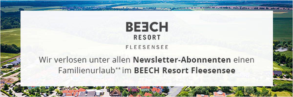 Luftaufnahme eines Dorfes mit einem Werbebanner für ein Familienurlaubsgeschenk im Beech Resort Fleesensee.
