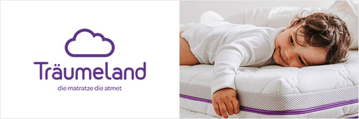 Ein Kind schläft friedlich auf einem Stapel Matratzen, umgeben von Bettwäsche, im Hintergrund ist eine Pflanze zu sehen. Links befindet sich das Logo von Träumeland.