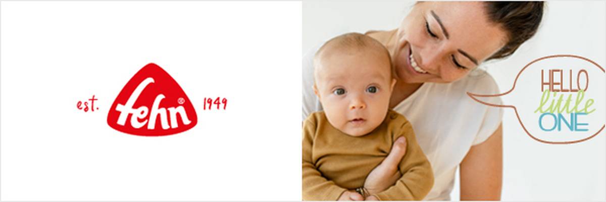 Lächelnde Frau, die ein Baby in brauner Kleidung hält, mit einem Plüschbären und dem Text „Hello Little One“ auf einem weißen Regal. Fehn-Logo auf der linken Seite.