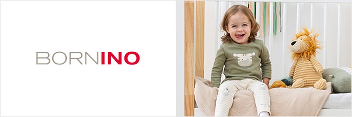 Ein lächelndes Kind sitzt mit einem Stofflöwen auf einem Bett. Das Zimmer ist in sanften Farben gehalten, an der Wand hängt eine Löwenabbildung. Darüber steht „BORNINO“.