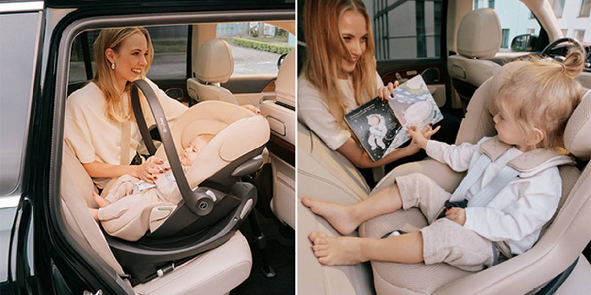 Eine Frau schnallt ein Baby in einem Kindersitz an und liest anschließend einem Kleinkind im Auto vor. Beide Kinder sitzen in beigefarbenen Kindersitzen.