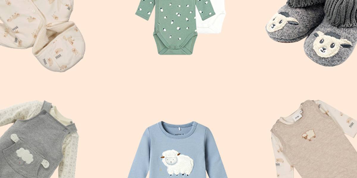 Babybekleidung und Accessoires mit Schafmotiven, darunter Strampler, ein Spielanzug, Hausschuhe und eine Decke, arrangiert auf hellem Hintergrund.
