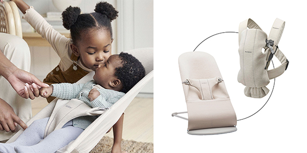 Ein junges Mädchen küsst sanft die Stirn eines Babys in einer Wippe. Auf der rechten Seite sind eine beige Babytrage und eine Wippe zu sehen.
