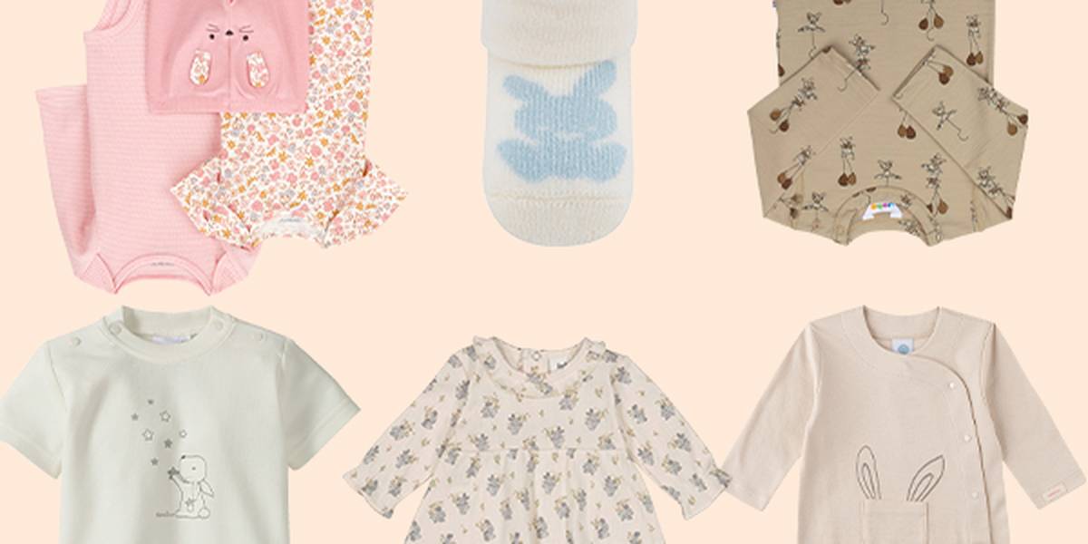 Verschiedene Babykleidung auf beigem Hintergrund, darunter Strampler, Kleider und ein Lätzchen mit Hasen- und Blumenmustern in sanften Pastellfarben.