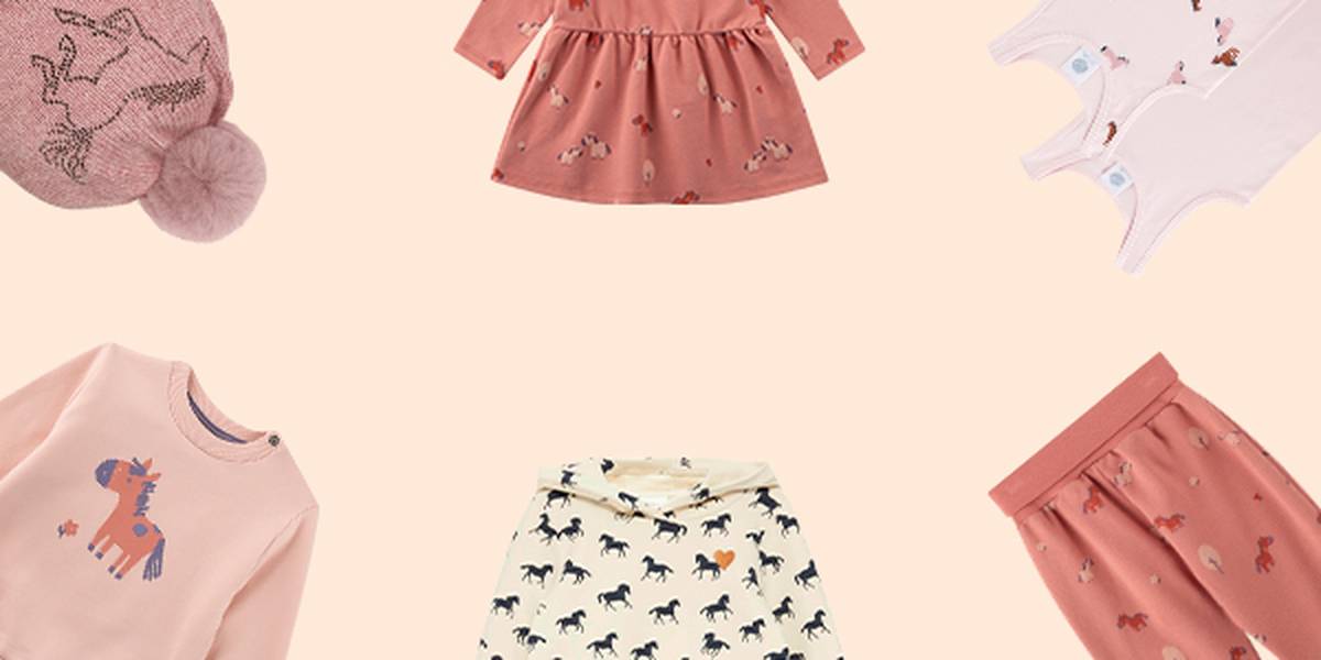 Kinderbekleidungskollektion mit Kleidern, Röcken und Oberteilen in Rosa und Creme mit Pferdemotiven, arrangiert auf hellem Hintergrund.