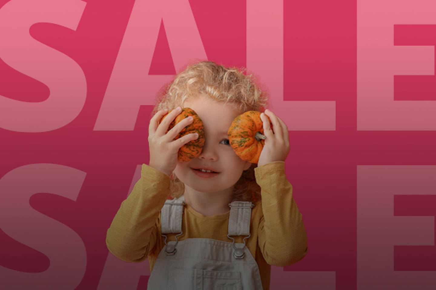 Kind mit lockigem Haar hält kleine Kürbisse vor die Augen, trägt ein gelbes Hemd und einen Overall vor einem rosa „SALE“-Hintergrund.