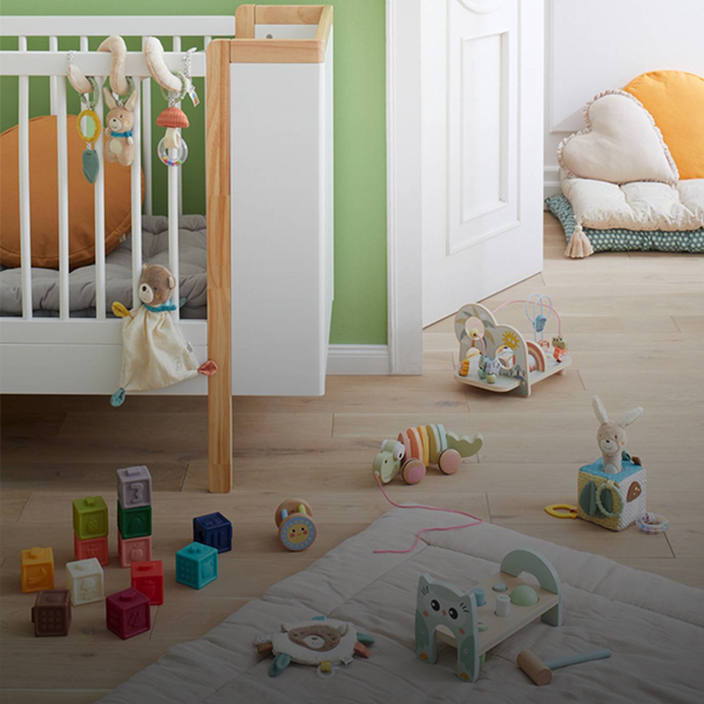 Ein gemütliches Kinderzimmer mit grünen Wänden, einem Kinderbett, Spielzeug und Regalen. Weiche Kissen und bunte Bauklötze liegen verstreut auf dem Holzboden.