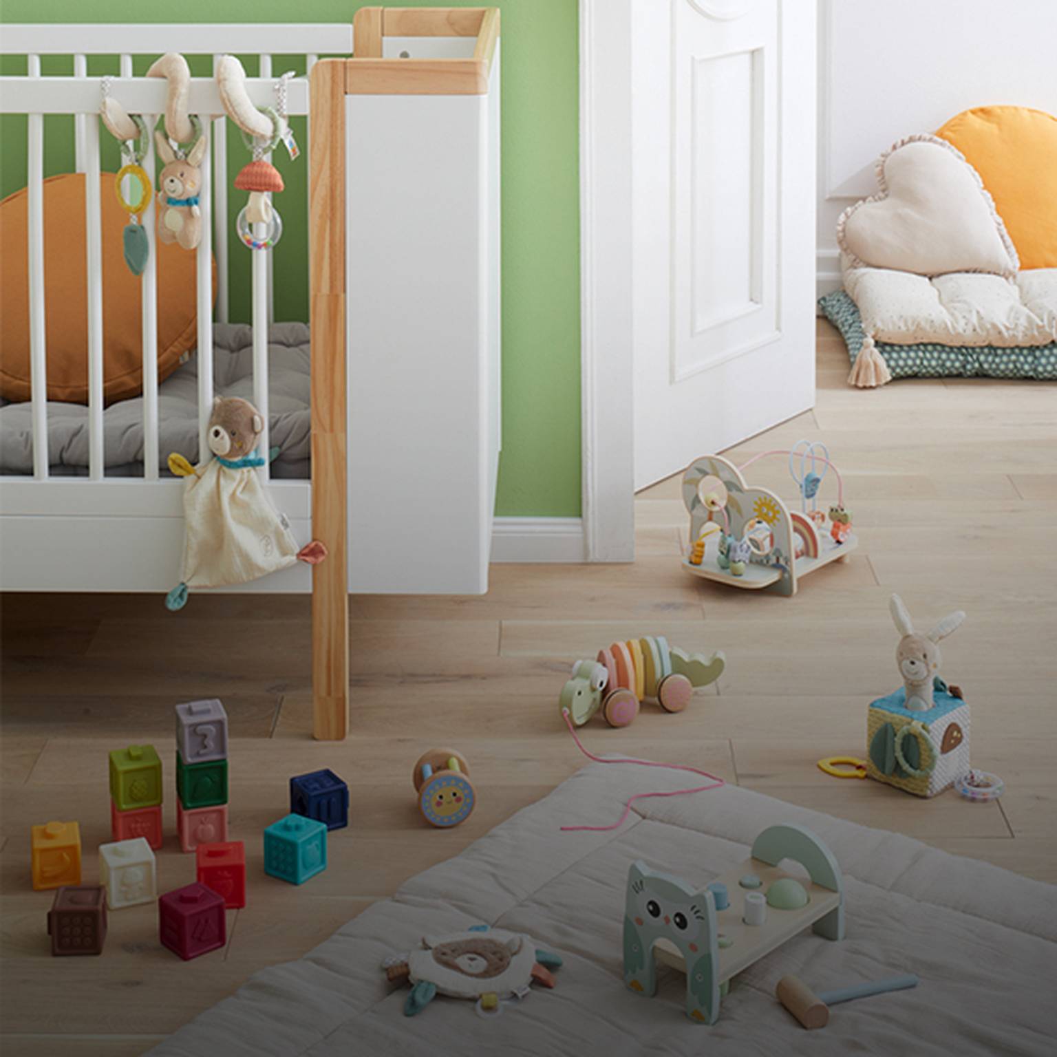 Ein gemütliches Kinderzimmer mit grünen Wänden, einem Kinderbett, Spielzeug und Regalen. Weiche Kissen und bunte Bauklötze liegen verstreut auf dem Holzboden.