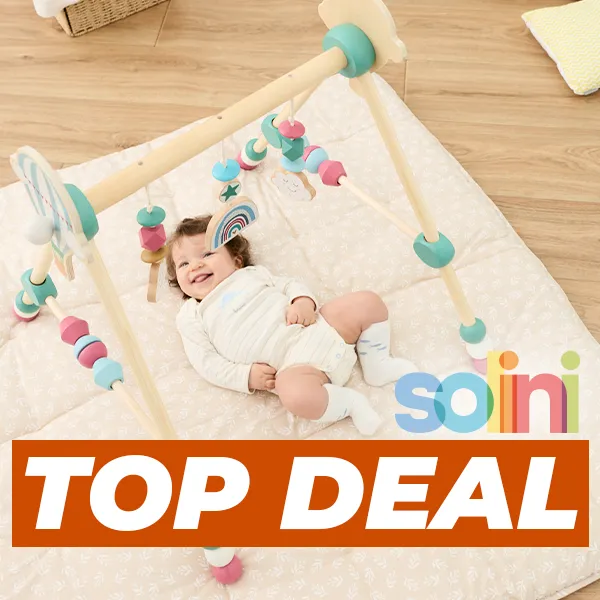 Ein Baby im Strampler lächelt unter einem hölzernen Spielbogen auf einer gepolsterten Matte. Auf dem Bild ist der Schriftzug „Solini Top Deal“ zu sehen.