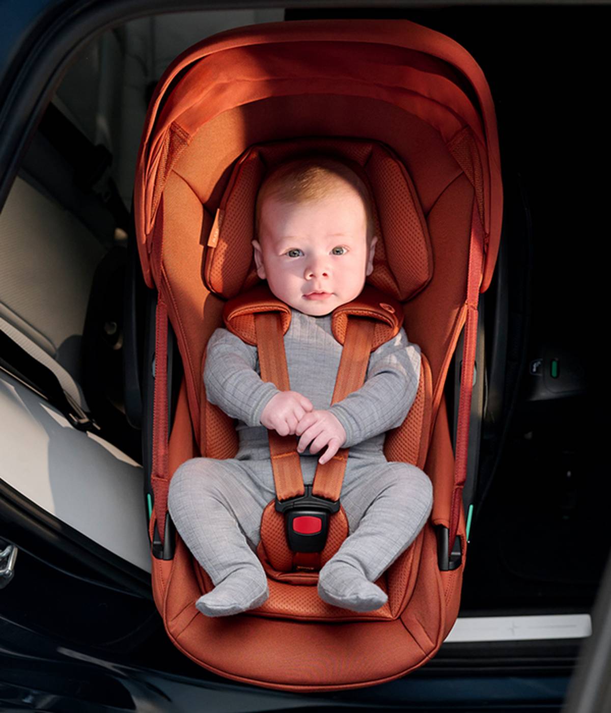 Ein Kind ist in einem Kindersitz angeschnallt.