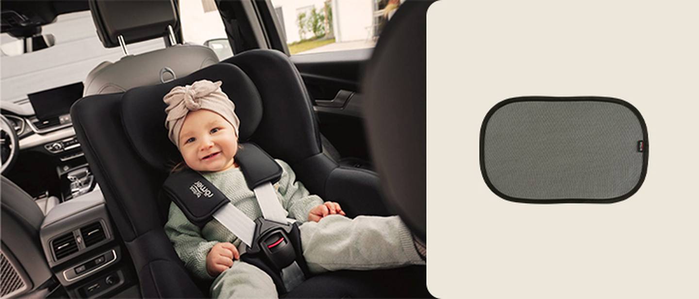 Ein Baby in einem Autositz mit einem Stirnband neben einem Sonnenschutz für das Autofenster auf beigem Hintergrund.