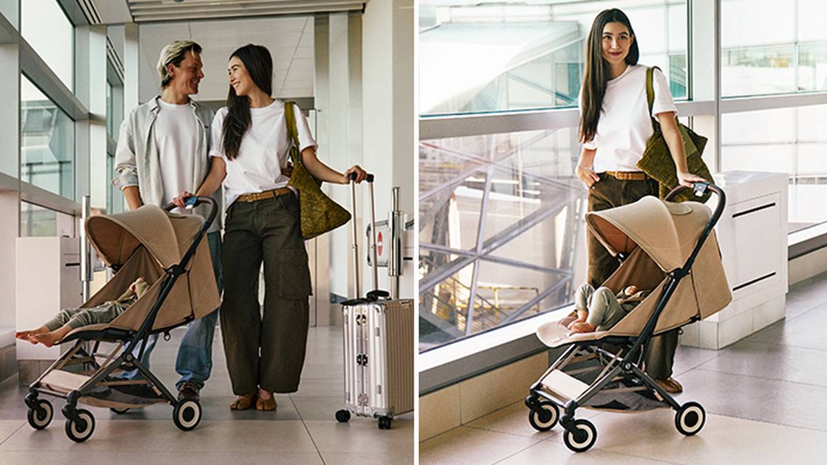 Ein Paar mit Baby im Kinderwagen geht mit Gepäck durch ein Flughafenterminal.