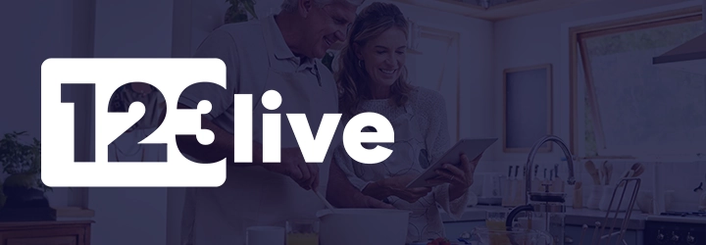 Ein Paar kocht zusammen in einer modernen Küche, mit dem Text „123 live“ auf der linken Seite.