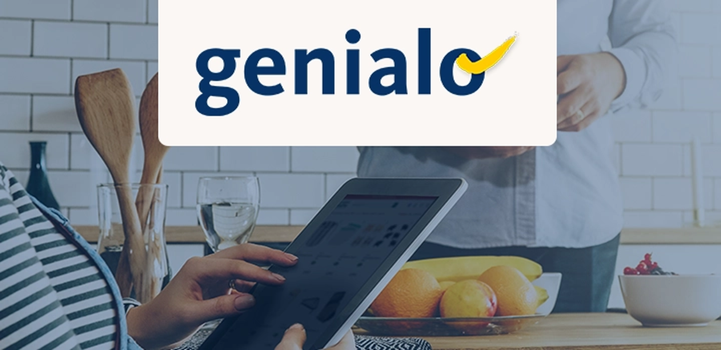 Person, die in einer Küche ein Tablet verwendet. In der Nähe stehen eine Obstschale, Holzutensilien und ein Glas Wasser. Oben das „Genialo“-Logo.