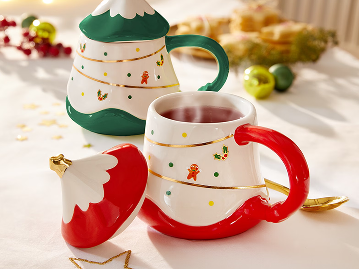 Festliche Tassen mit Weihnachtsbaum- und Weihnachtsmannmützen-Motiven, verziert mit Lebkuchen- und Stechpalmen-Illustrationen, auf einem weihnachtlich gedeckten Tisch.