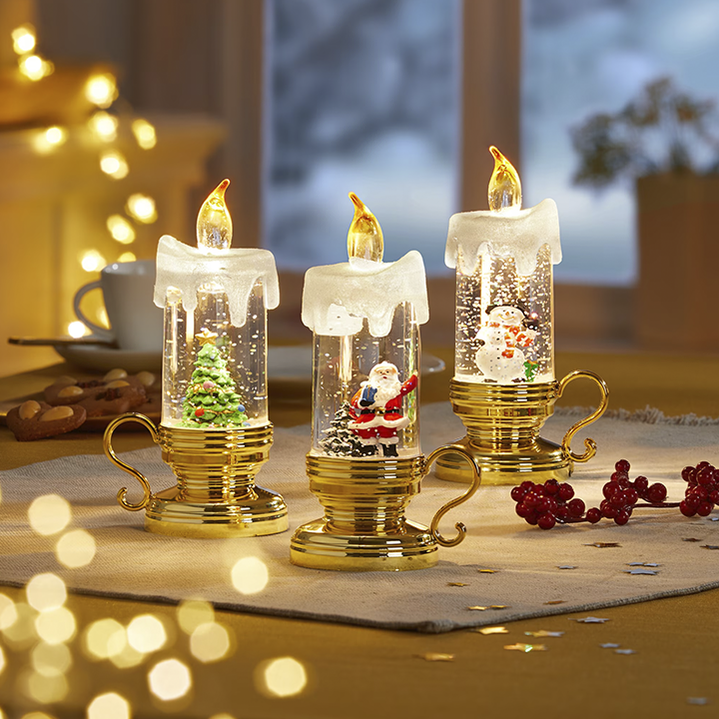 Drei dekorative Schneekugelkerzen mit festlichen Motiven im Inneren, darunter ein Baum, der Weihnachtsmann und ein Schneemann, auf einem Tisch mit warmer Beleuchtung im Hintergrund.