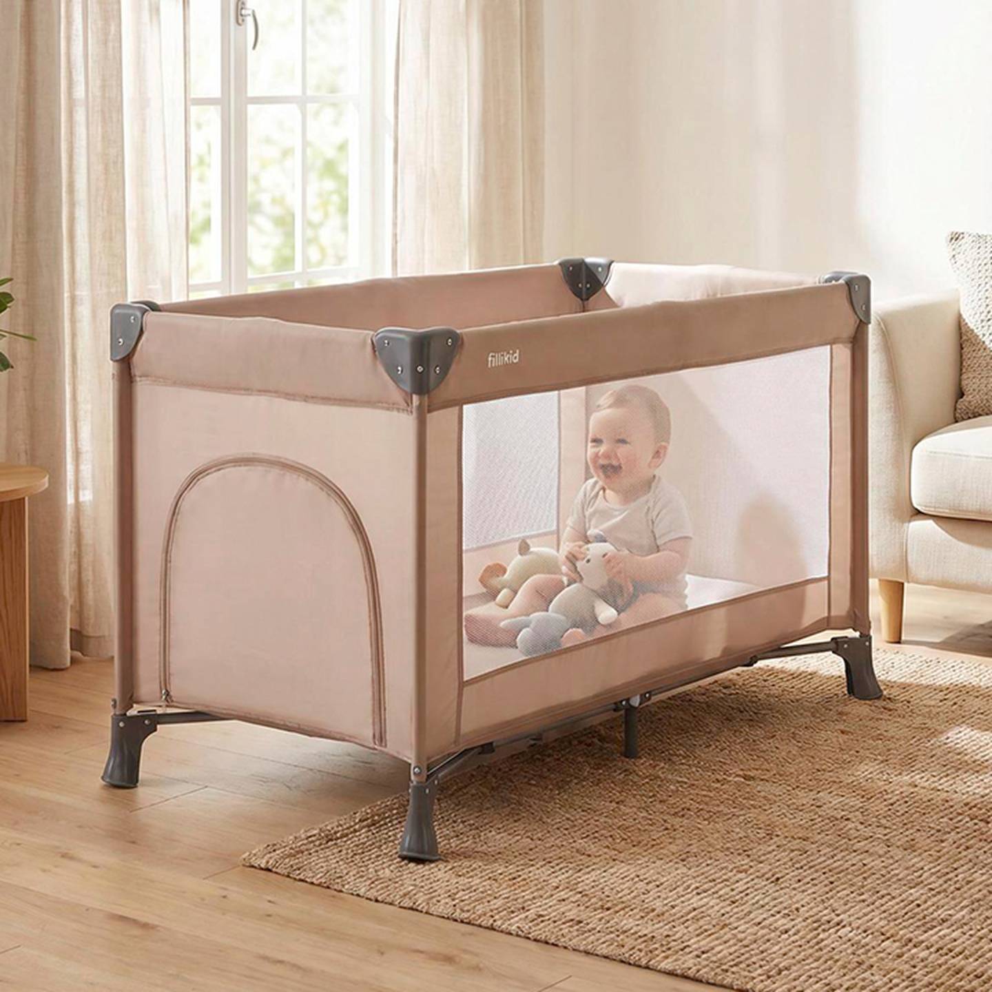 Ein lächelndes Baby sitzt in einem beigen Laufstall voller Plüschtiere, in einem sonnendurchfluteten Raum mit einem Fenster, einem Teppich und einem Sofa.