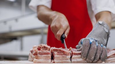 Fleischverarbeitung mit Messer und passendem Schnittschutz der Hand.