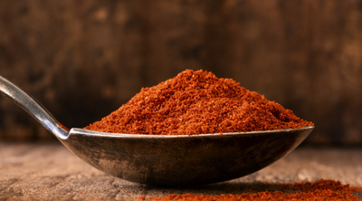 Leuchtend rotes Paprikapulver auf einem Metall-Löffel