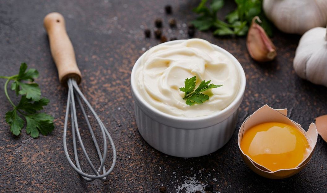 Mayonnaise mit möglichen Zutaten wie Ei, Knoblauch, Gewürzen und Kräutern.