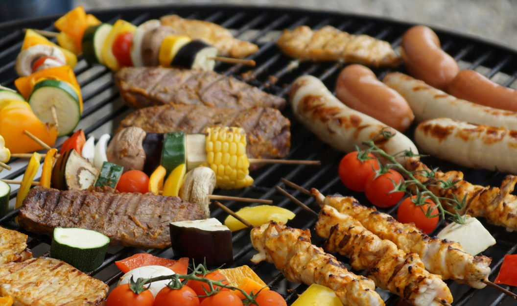 Gemüse, Würstchen und Fleischspieße auf dem Grill – beliebte Klassiker der Grillsaison