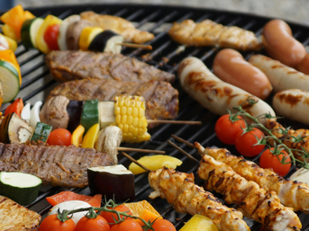Gemüse, Würstchen und Fleischspieße auf dem Grill – beliebte Klassiker der Grillsaison
