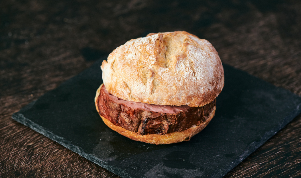 Ein saftiges Stück Leberkäse mit einer goldbraunen Kruste im Brötchen.