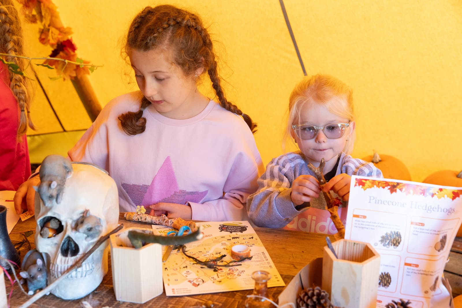 Two girls sitting at a table doing halloween crafts