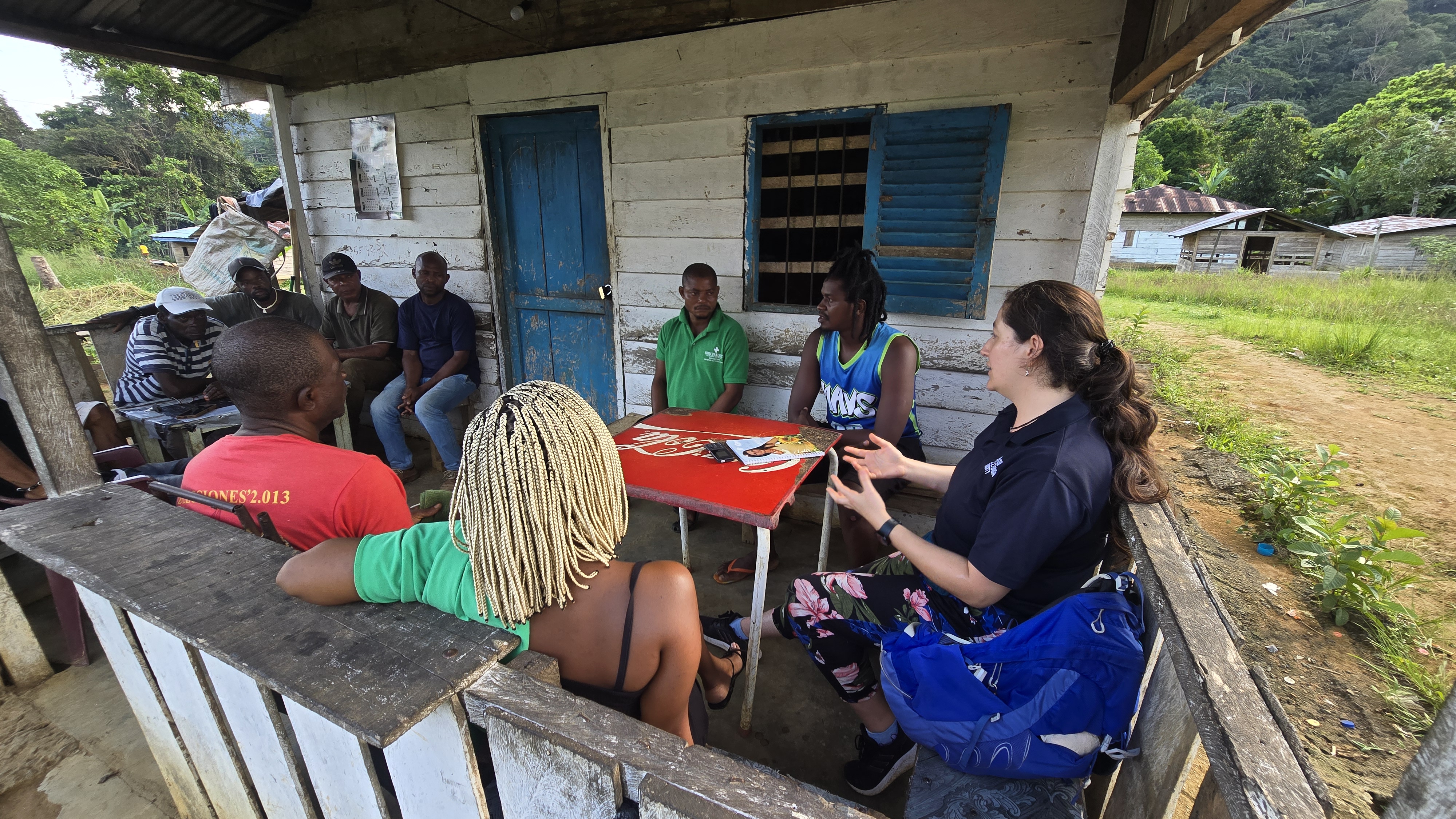 A group of people sitting on the porch of a wooden house