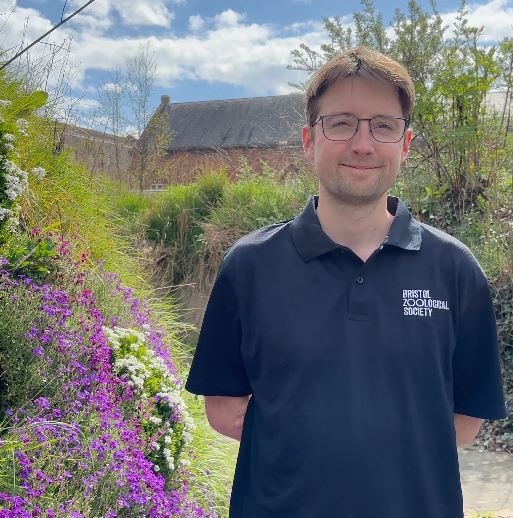A person standing in front of a flower bed