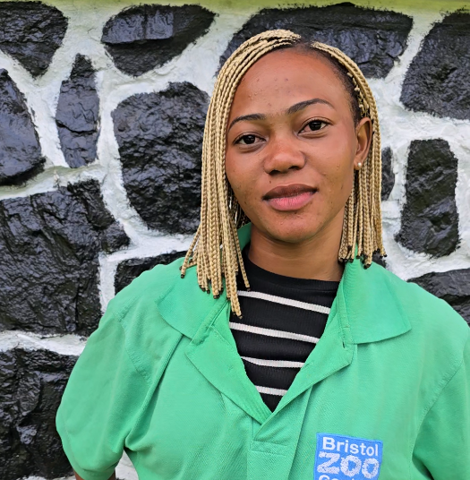A woman with a Bristol Zoo shirt on standing infront of a wall