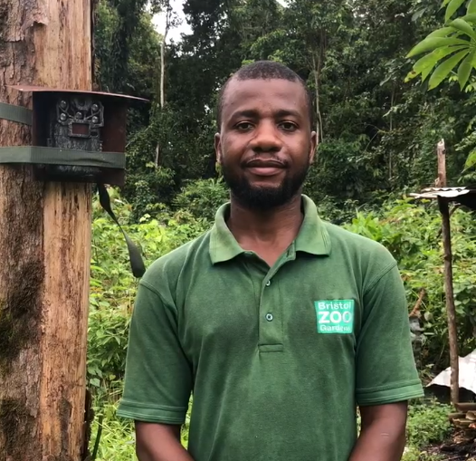 A man standing in a Bristol Zoo tshirt infront of a forest
