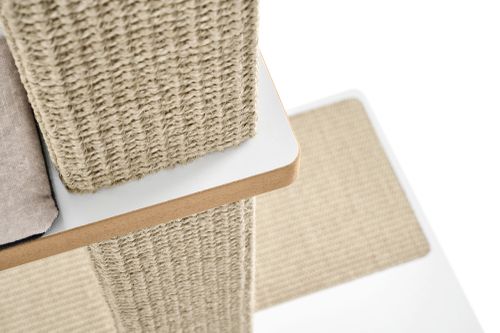 Nahaufnahme eines Kratzbaumstamms mit grob gewebtem Sisal und einer weißen Plattform mit abgerundeten Holzkanten; im Hintergrund eine weitere sisalbezogene Fläche.