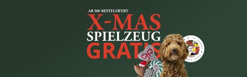 Dunkelgrünes Banner mit der Aufschrift „X-MAS SPIELZEUG GRATIS” in fetter rot-weißer Schrift, darauf ein kleiner brauner Lockenhündchen, der Weihnachtsspielzeug hält.