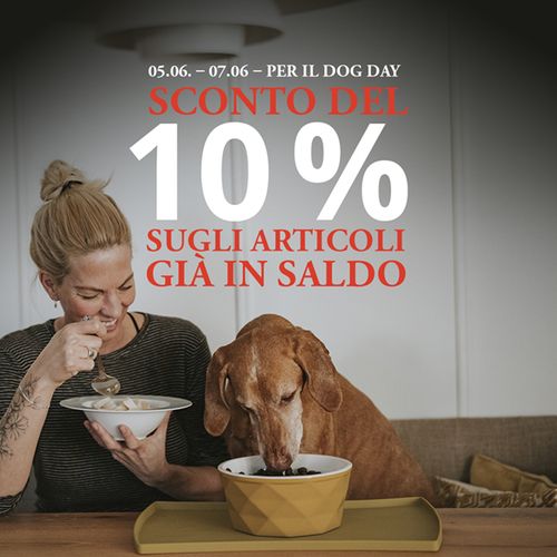 Immagine promozionale con scritta rossa e bianca: “05/06 – 07/06 – PER IL DOG DAY: 10% SCONTO DEL 10% SUGLI ARTICOLI GIÀ IN SALDO”  Sullo sfondo si vede un’immagine realistica di una donna e un cane seduti a un tavolo mentre mangiano qualcosa. La donna guarda felicemente il suo cane.