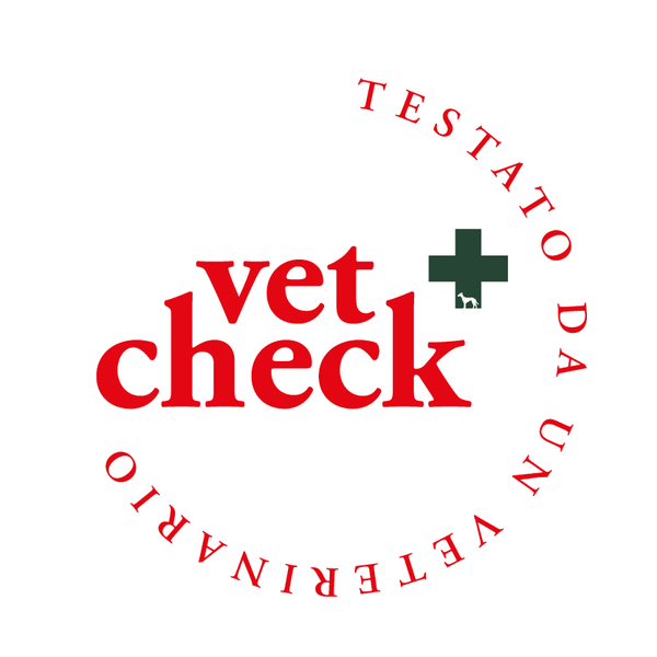 Logo rotondo con la scritta “vet check” in rosso e una croce verde, circondato dalla scritta “TESTATO DA UN VETERINARIO” in rosso.