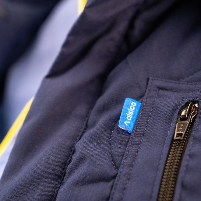 Monviso industrial jacket showcased in a commercial laundry environment, Alsico workwear.