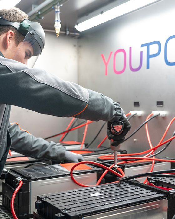 Worker in safety gear operating electrification recycling equipment.