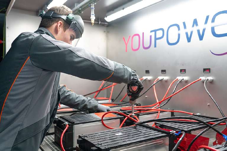 Worker in safety gear operating electrification recycling equipment.
