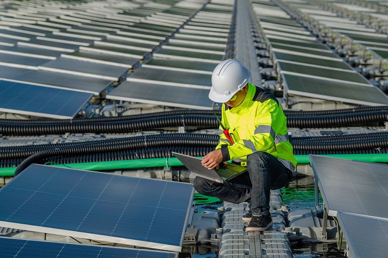 Electric power infrastructure and arc flash uniform wearer emphasising energy and electrification safety.