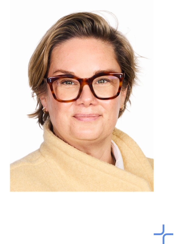 Sarah smiles at the camera, wearing black glasses.