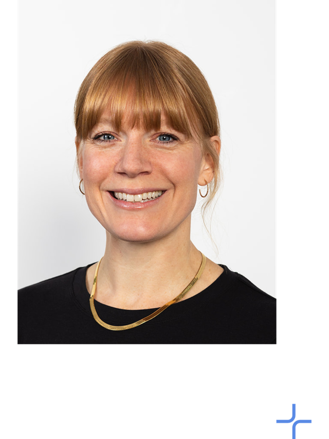 Lauren Milne wears a black shirt and a gold necklace.