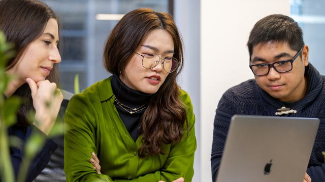 Candice, Lulu, and Michael collaborate on a laptop.