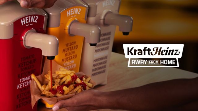 Three condiment dispensers for ketchup, mustard, and mayonnaise; ketchup being added to fries. Kraft Heinz "Away from Home" branding visible.