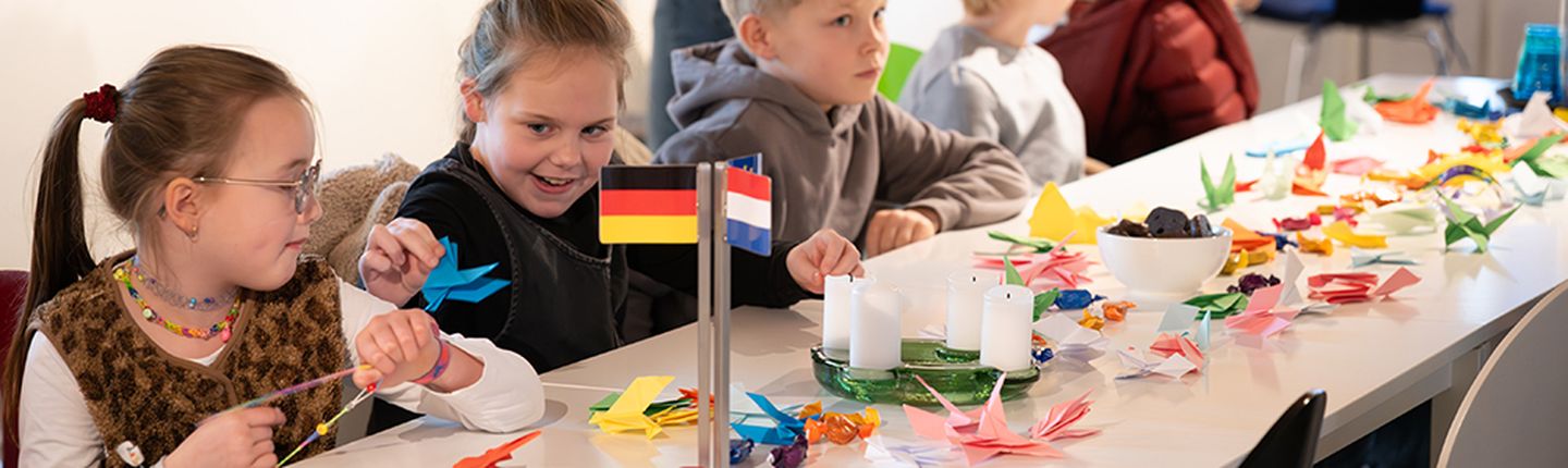 Kinder sitzen an einem Tisch