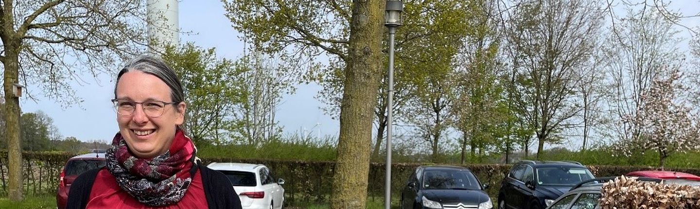 Referentin Anna Langer steht vor einem Schild der EGW