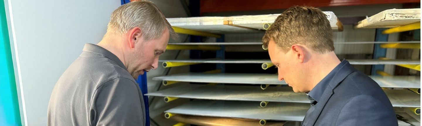Bürgermeister Dr. Tom Tenostendarp betrachtet in der Großformatdruck-Abteilung langlebige, kratzfeste Digitaldrucke auf Blenden für den industriellen Einsatz.
