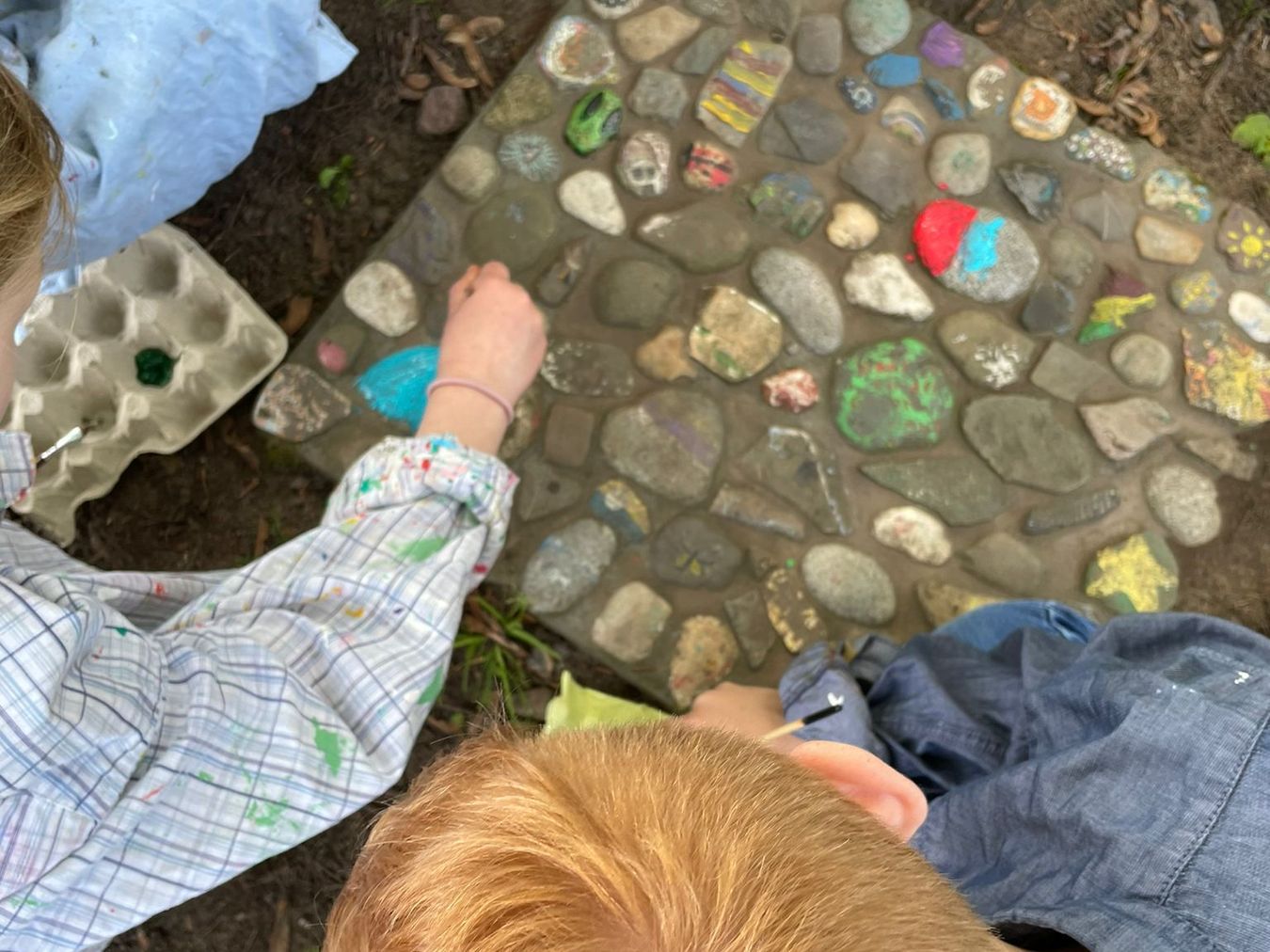 Kinder der Marienschule bemalen die in Beton gegossenen Steine