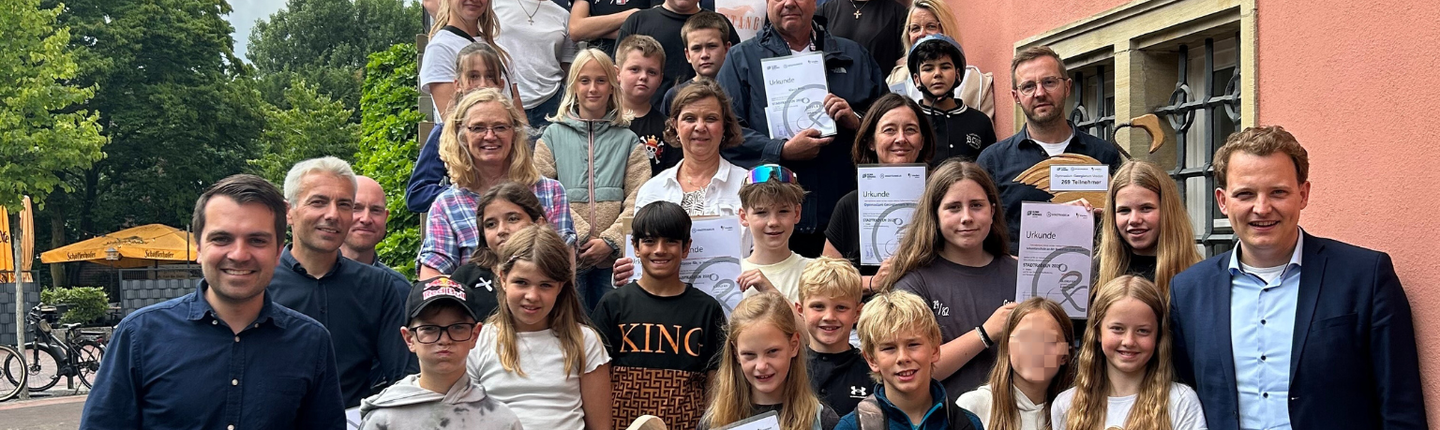 Gruppenbild aller Teilnehmenden der Siegerehrung auf der Rathaustreppe
